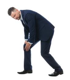 Full length portrait of businessman having knee problems on white background