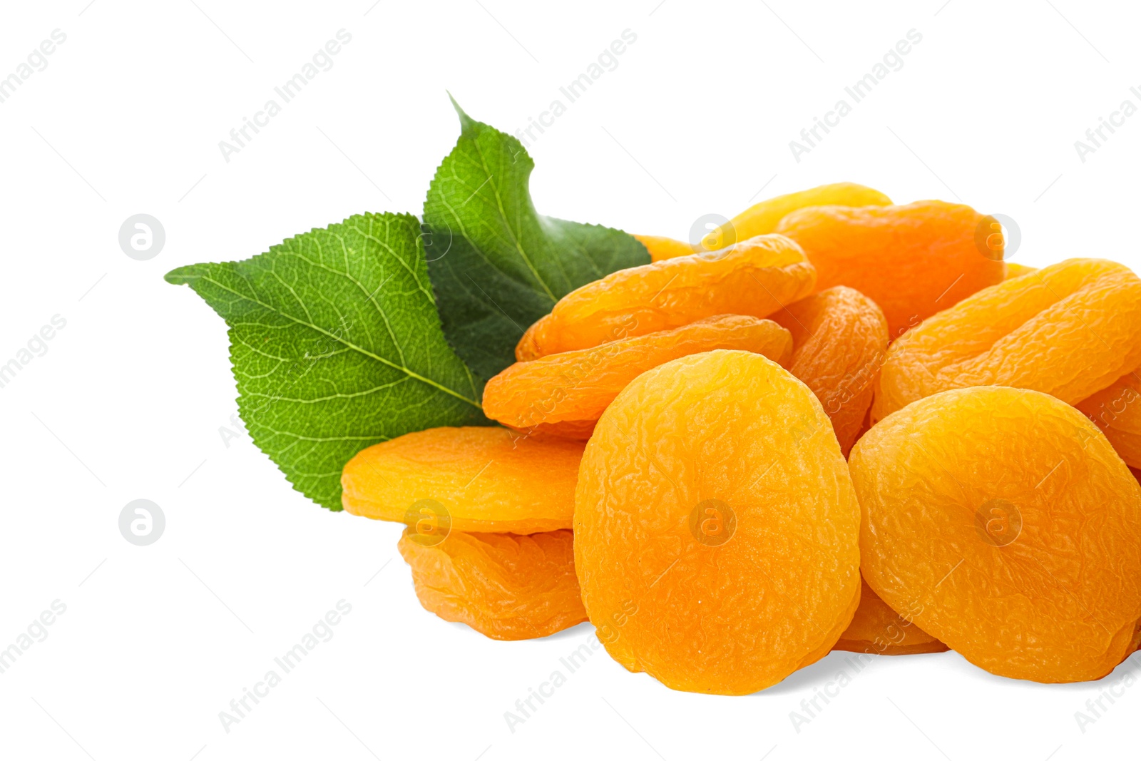 Photo of Pile of tasty apricots and green leaves on white background. Dried fruits