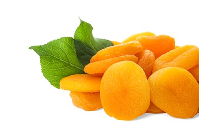 Photo of Pile of tasty apricots and green leaves on white background. Dried fruits