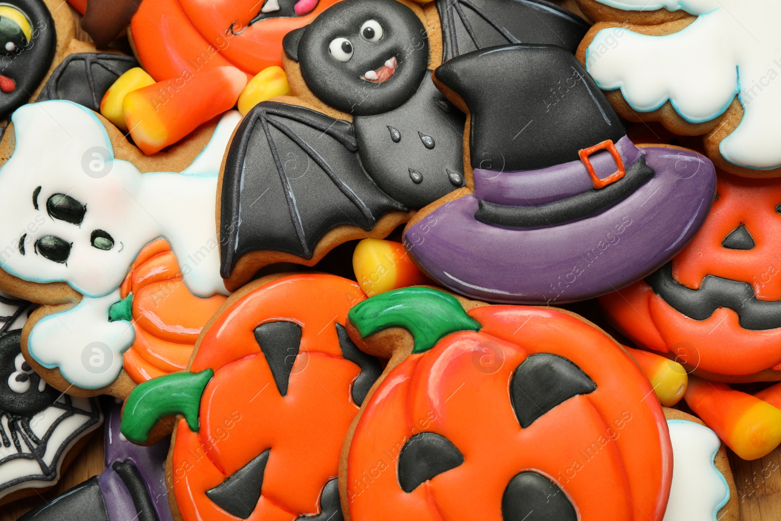 Photo of Top view of tasty cookies and sweets for Halloween party as background, closeup