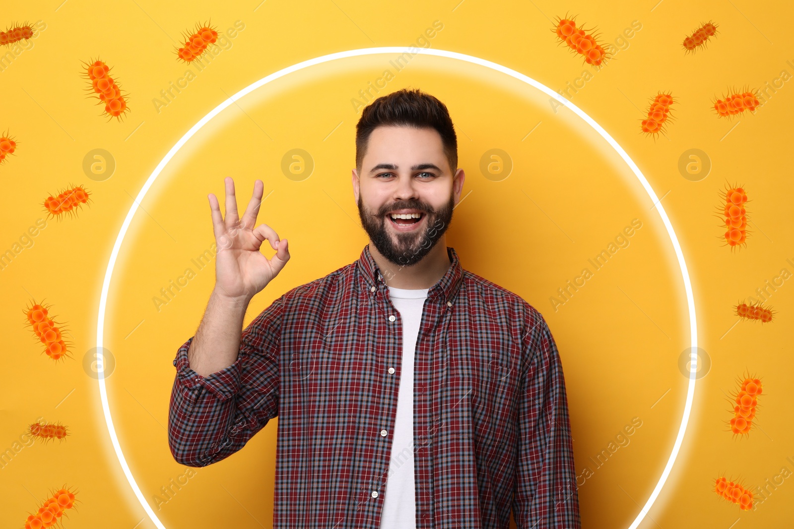 Image of Man with strong immunity surrounded by viruses on orange background