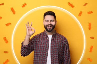 Man with strong immunity surrounded by viruses on orange background