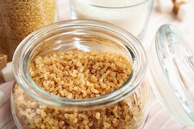 Photo of Glass bowl with brown sugar on table, closeup