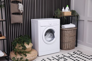 Photo of Stylish laundry room interior with washing machine