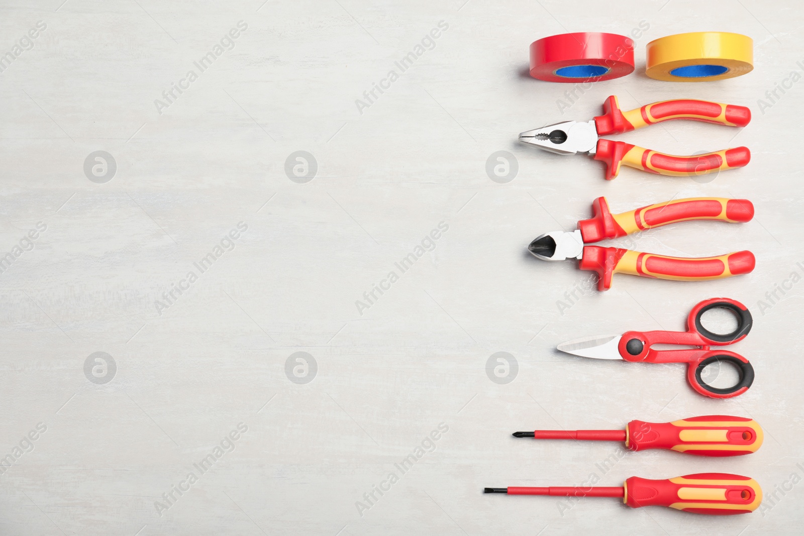 Photo of Flat lay composition with electrician's tools and space for text on light background