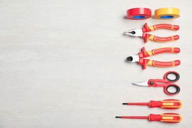 Flat lay composition with electrician's tools and space for text on light background