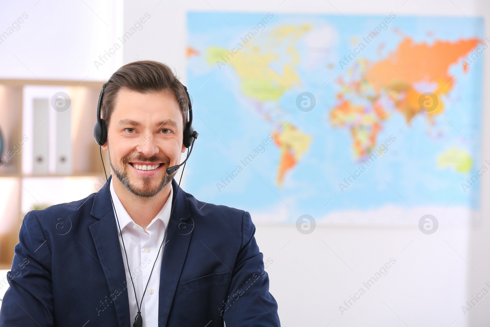 Photo of Male consultant with headset in travel agency. Space for text