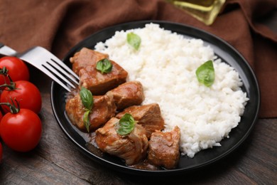 Photo of Delicious goulash served with rice on wooden table, closeup