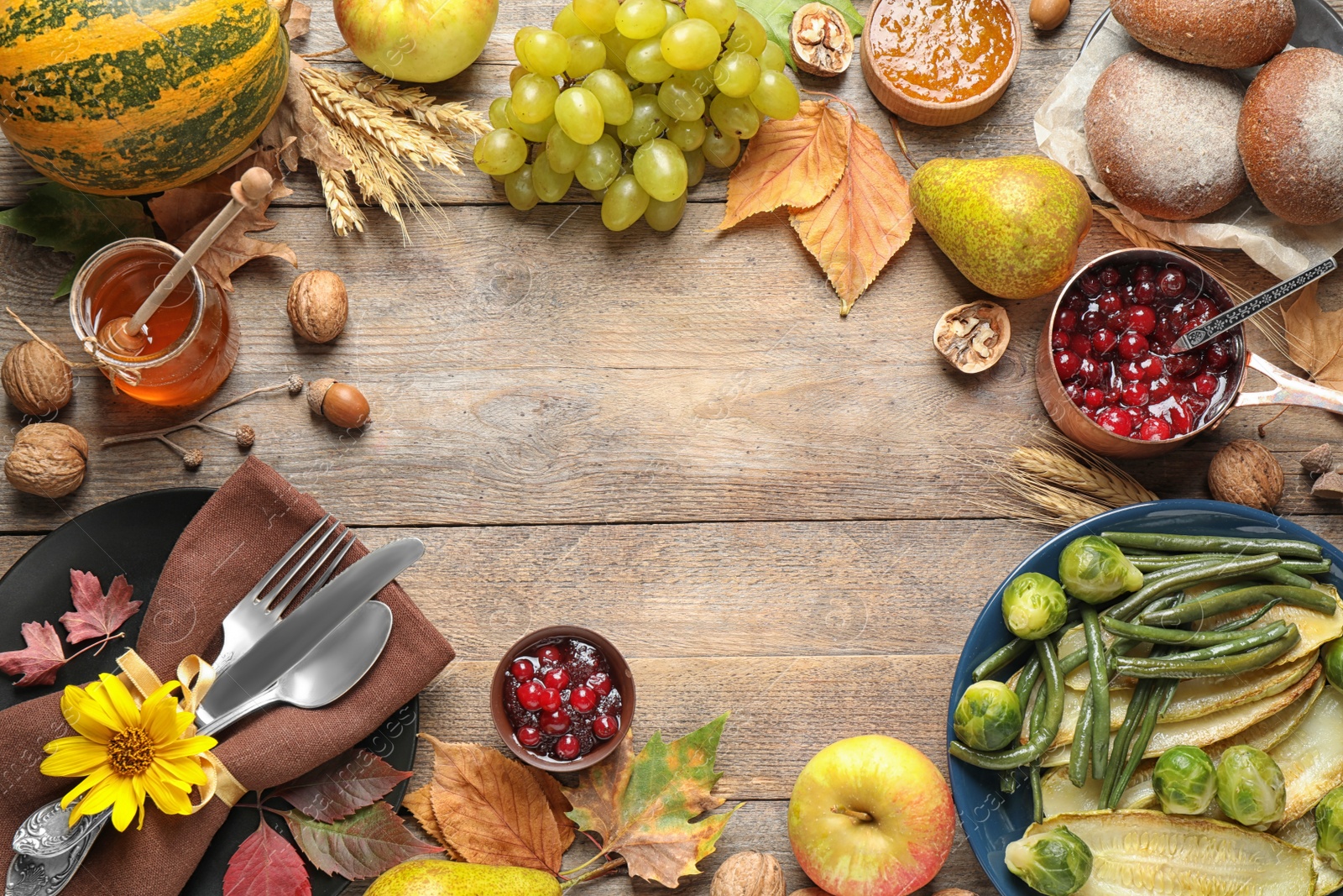 Photo of Frame made of autumn vegetables, fruits and cutlery on wooden background, flat lay with space for text. Happy Thanksgiving day