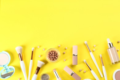 Photo of Flat lay composition with makeup brushes on yellow background, space for text