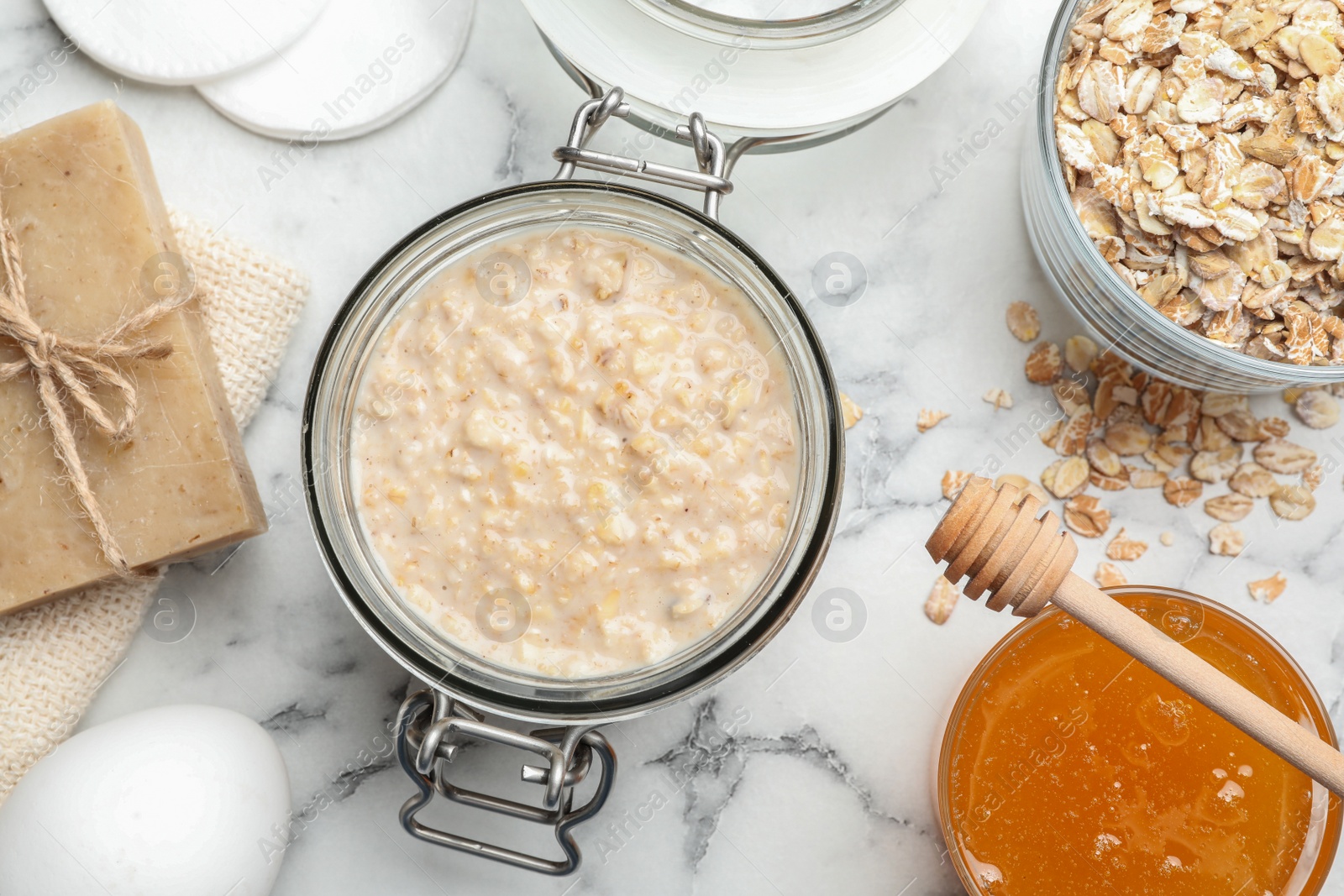 Photo of Handmade face mask and ingredients on white marble table, flat lay