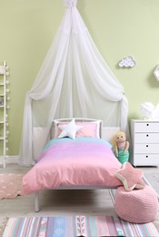Photo of Cute child's room interior with comfortable bed and curtain