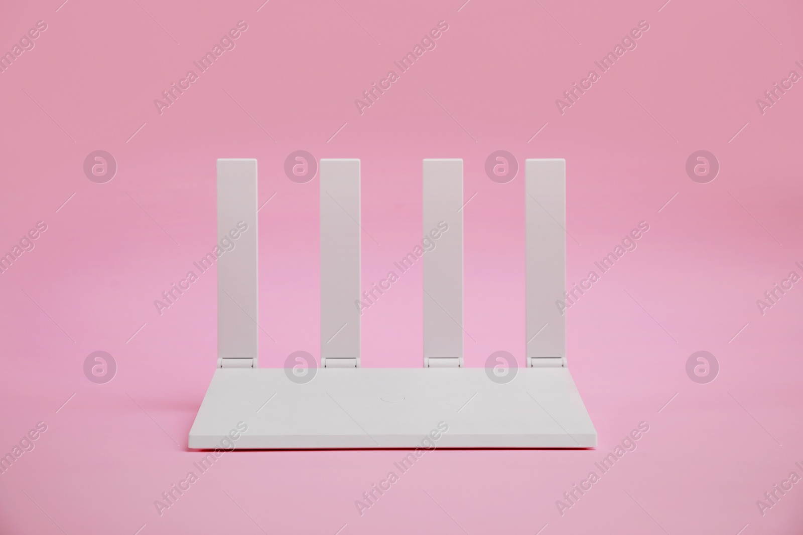 Photo of One modern Wi-Fi router on pink background