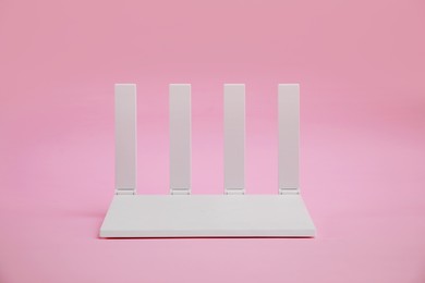 Photo of One modern Wi-Fi router on pink background