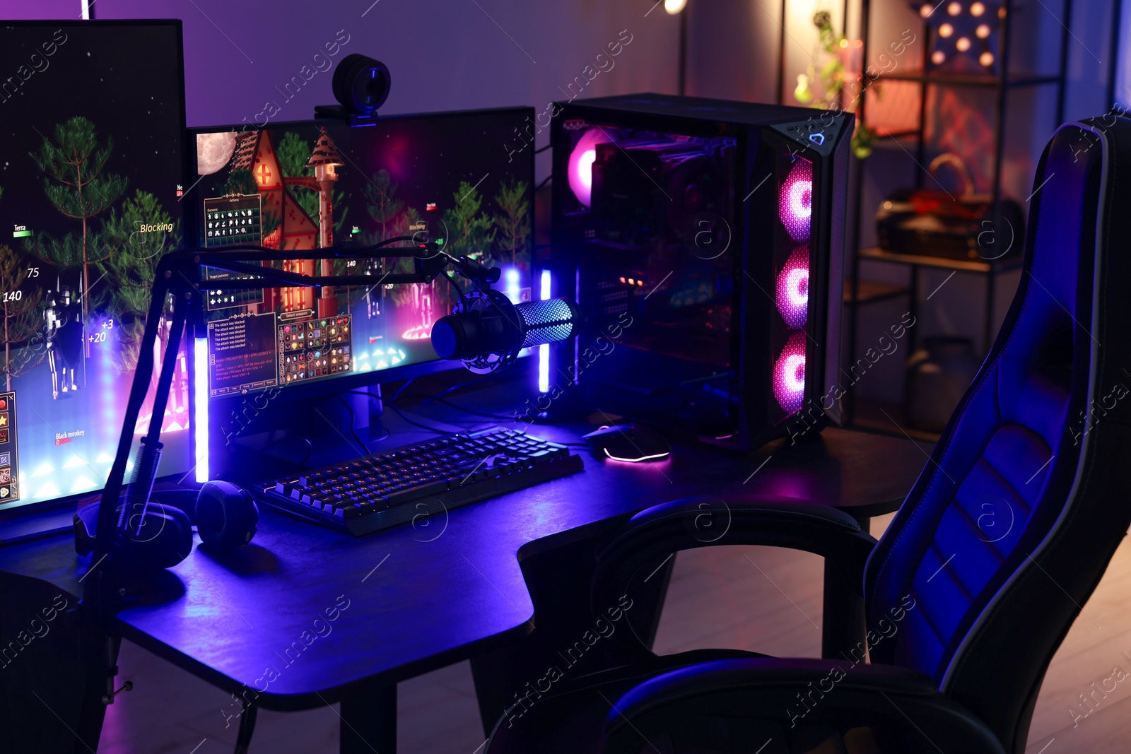 Photo of Playing video games. Stylish room interior with modern computer and gaming chair in neon lights