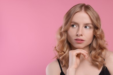 Portrait of beautiful woman with blonde hair on pink background. Space for text