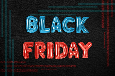 Image of Phrase BLACK FRIDAY made of foil balloon letters on dark background