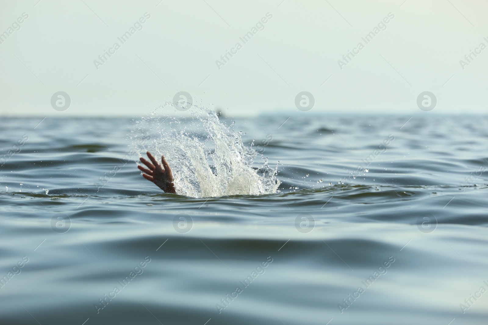 Photo of Drowning woman reaching for help in sea