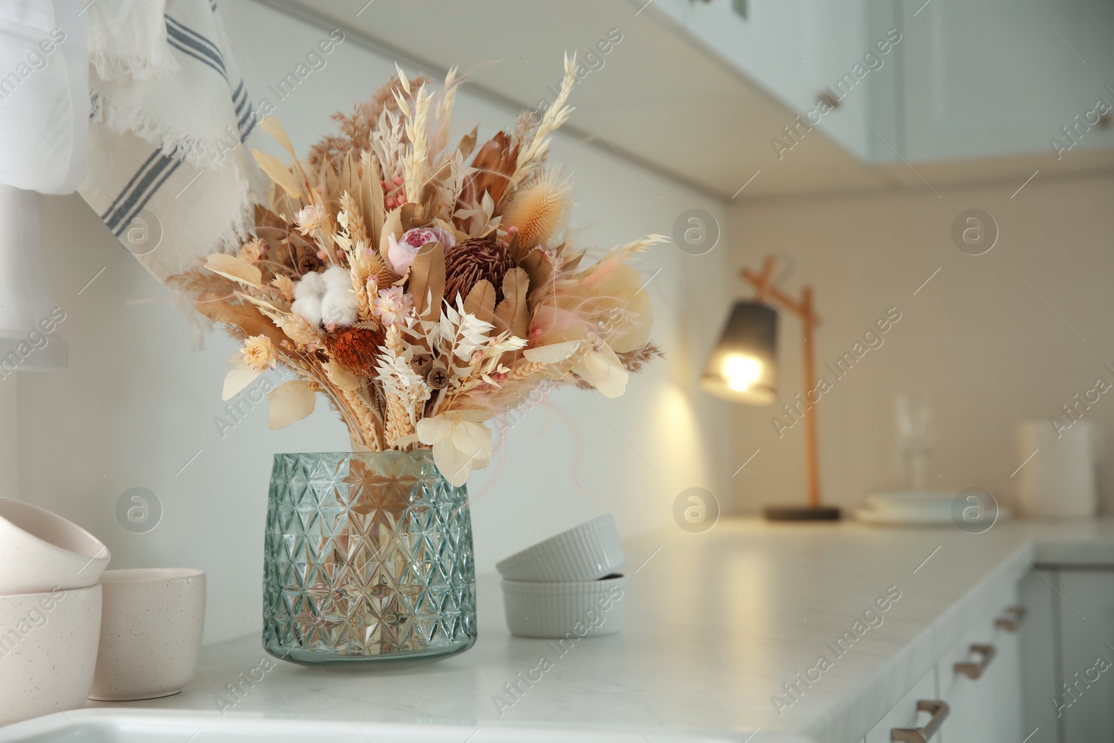Photo of Bouquet of dry flowers and leaves on countertop in kitchen. Space for text