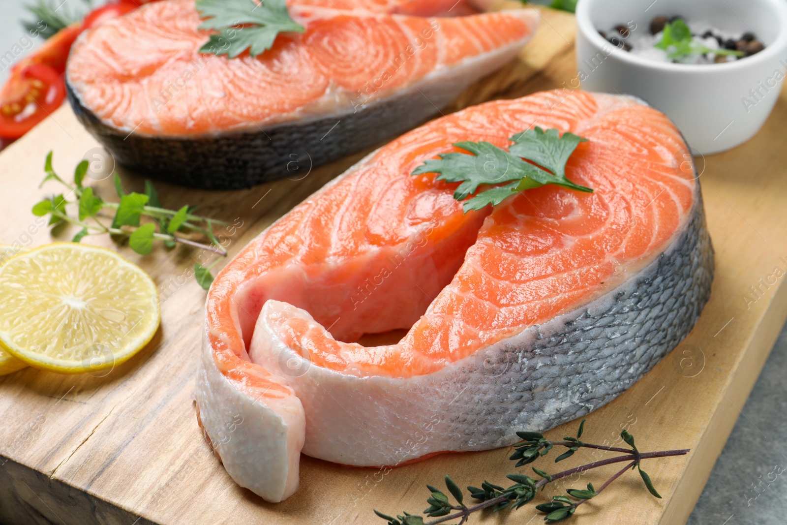 Photo of Fresh salmon and ingredients for marinade on wooden board, closeup