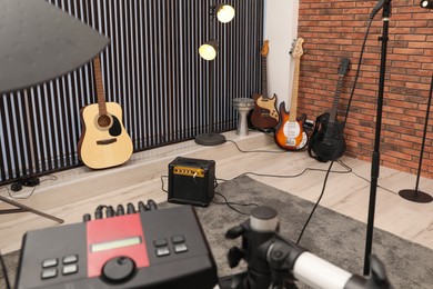 Photo of Modern music studio with microphone and different electronic instruments