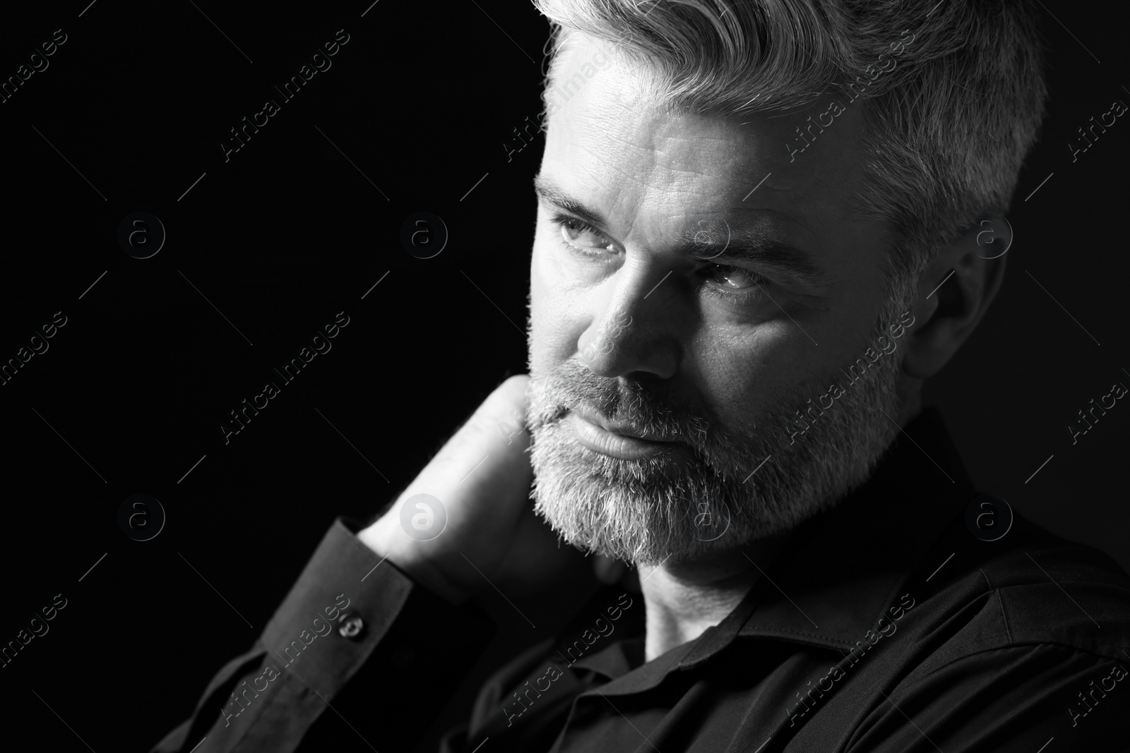 Photo of Portrait of handsome man on dark background. Black and white effect