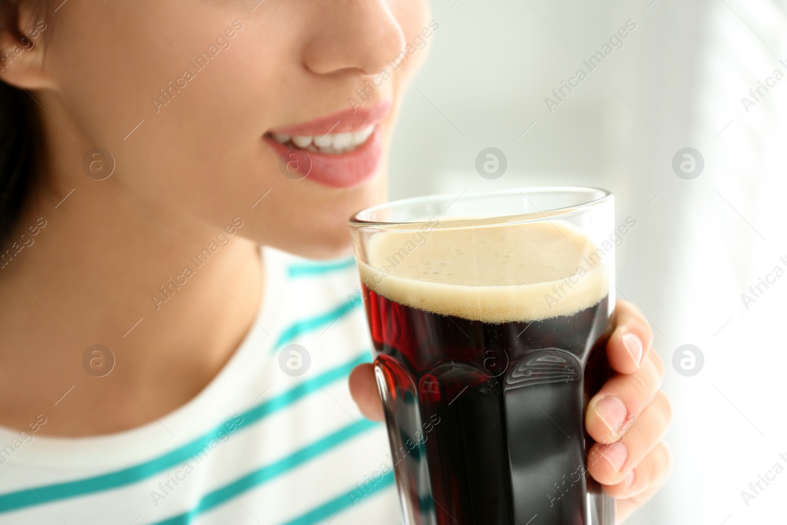 Photo of Young woman with cold kvass indoors, closeup. Traditional Russian summer drink