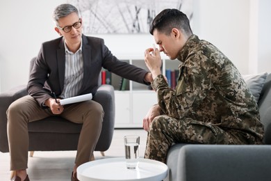 Professional psychotherapist working with military man in office