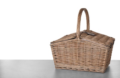 Photo of Closed wicker picnic basket on white background, space for text