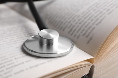 Photo of Open student textbook with and stethoscope, closeup. Medical education