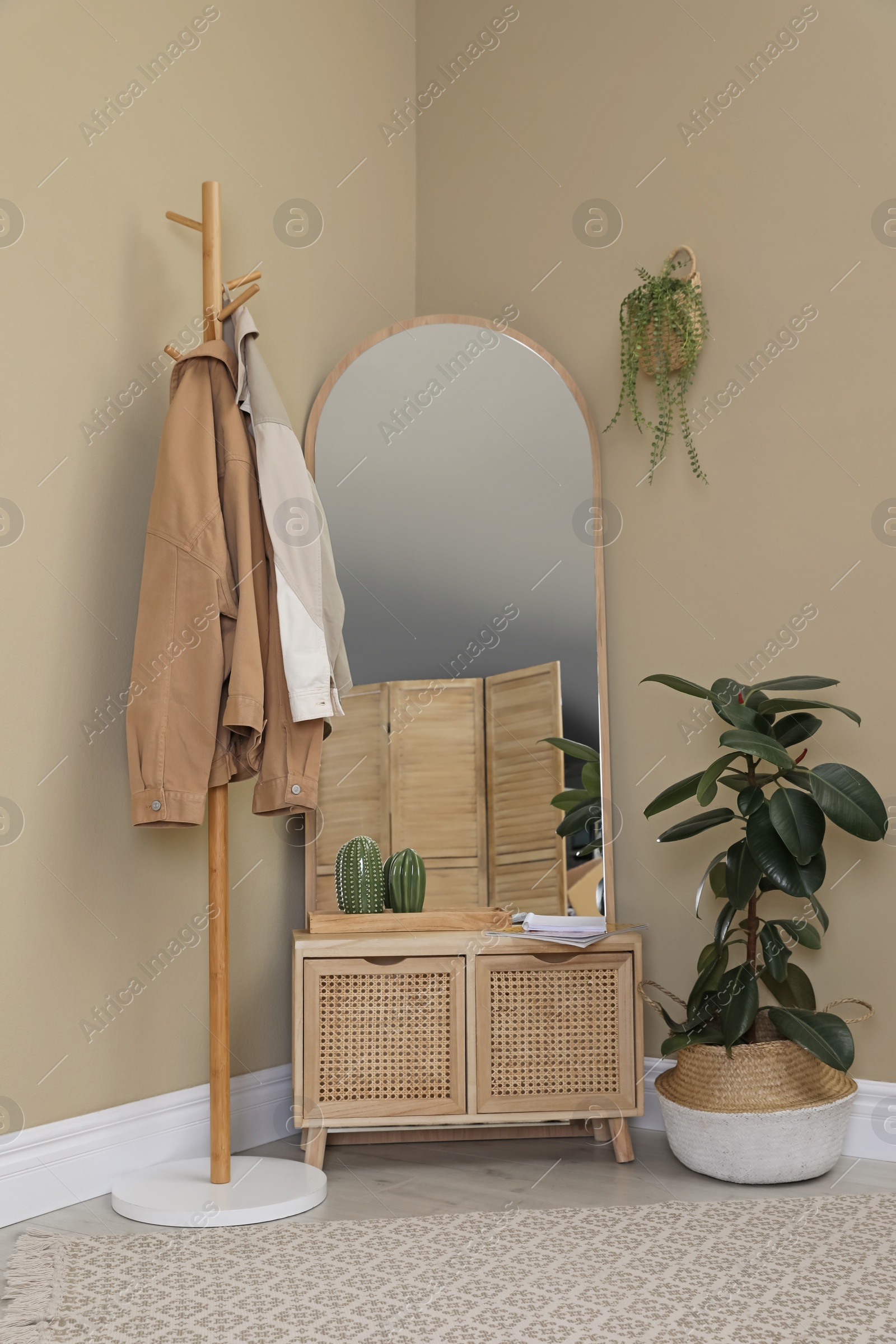 Photo of Stylish hallway room interior with wooden commode, coat rack and large mirror