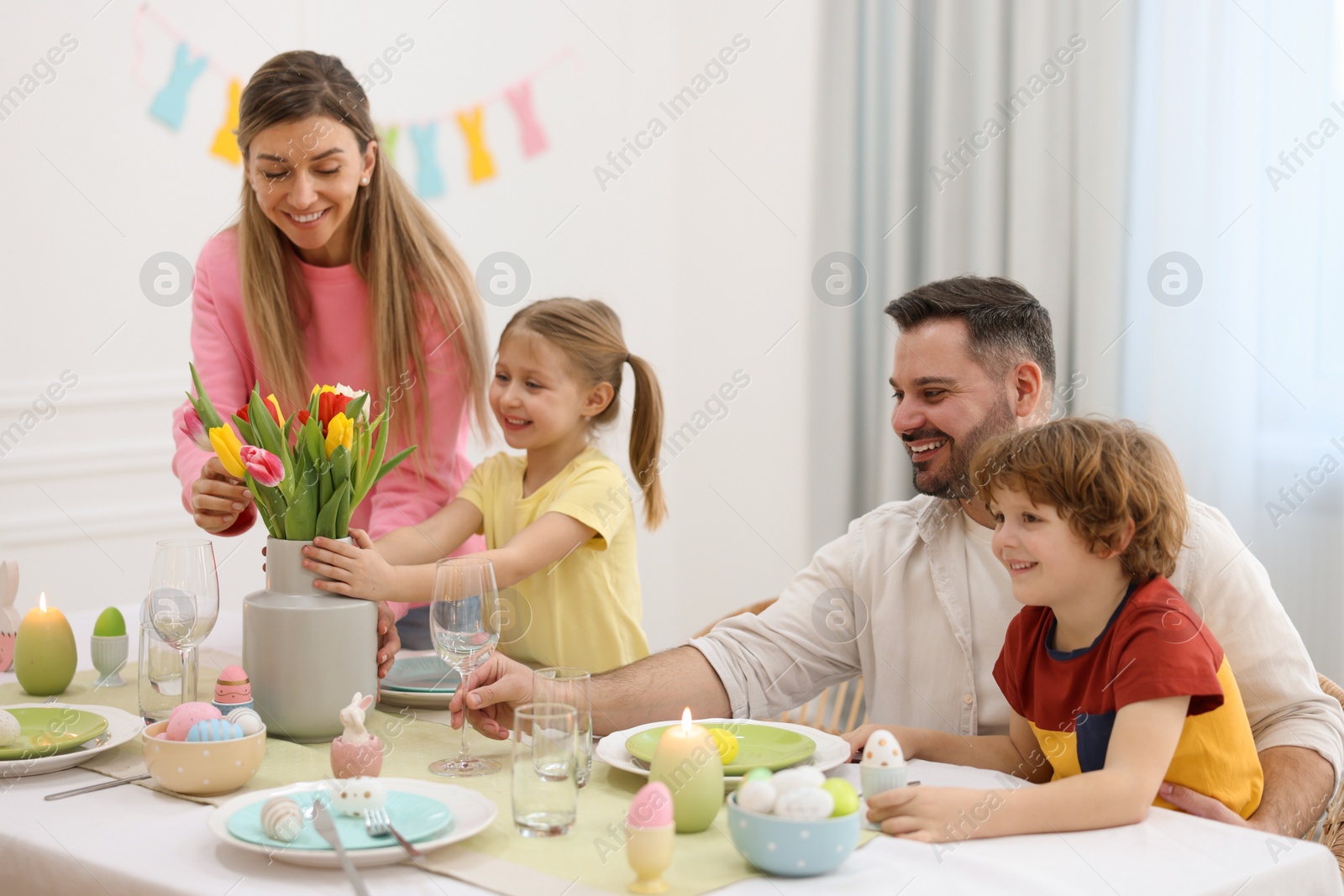 Photo of Easter celebration. Happy family setting table at home