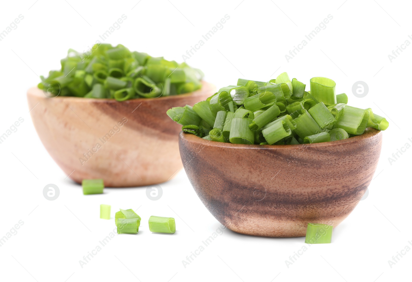 Photo of Chopped fresh green onion in bowls isolated on white