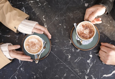 Photo of Couple enjoying tasty aromatic coffee at table, view from above