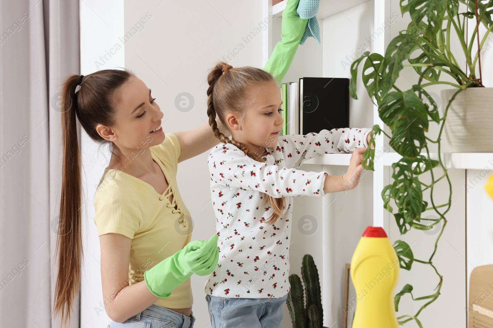 Photo of Spring cleaning. Mother and daughter tidying up together at home