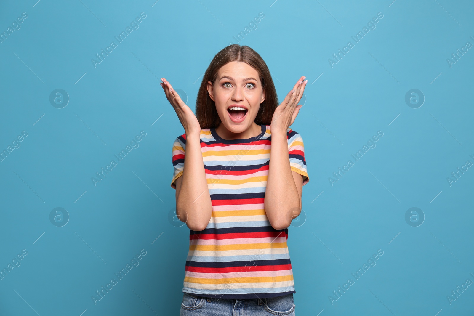 Photo of Portrait of emotional young woman on light blue background