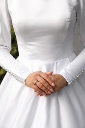Photo of Bride wearing beautiful engagement ring and wedding dress, closeup