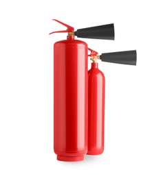 Two red fire extinguishers on white background