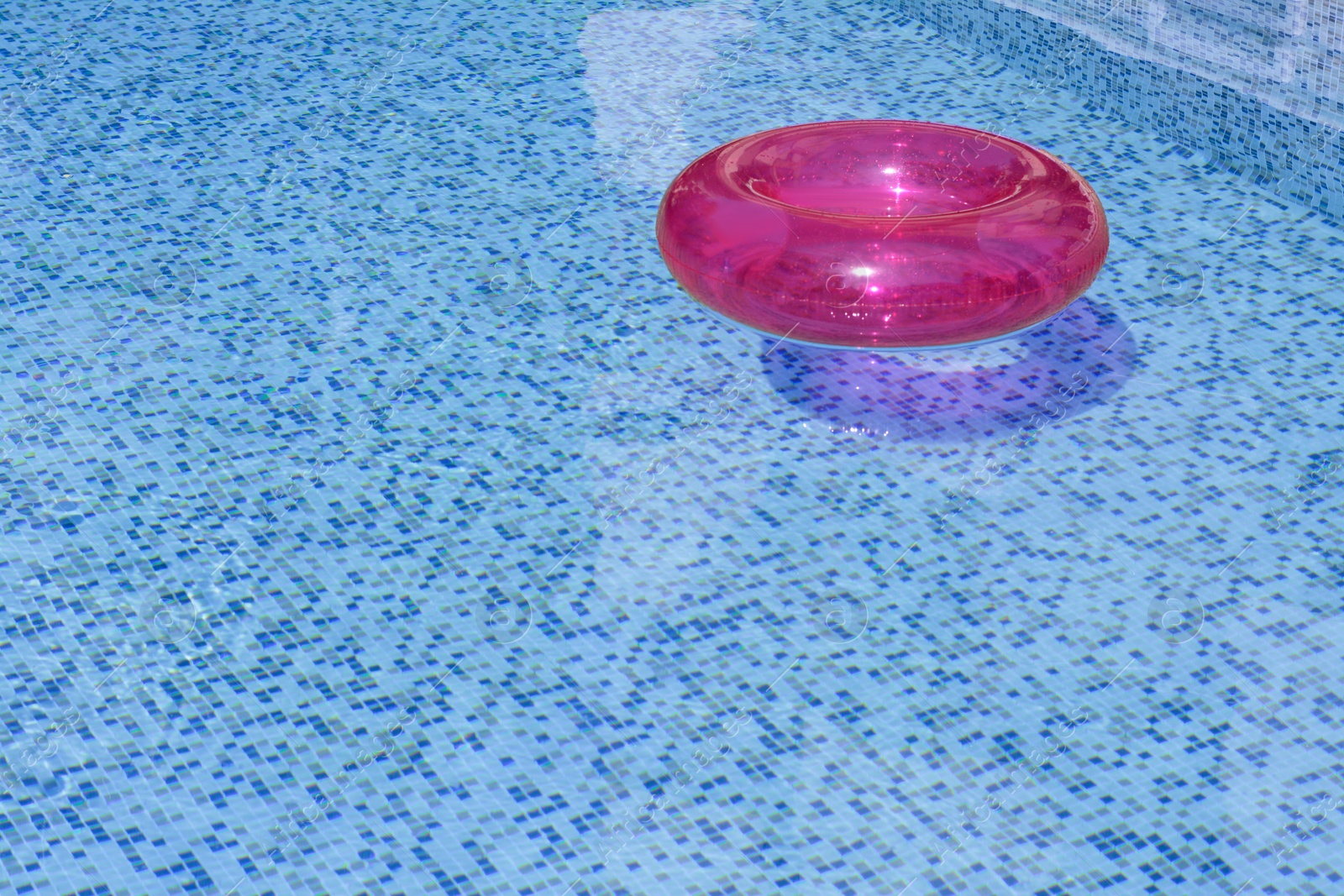 Photo of Inflatable ring floating on water in swimming pool, space for text