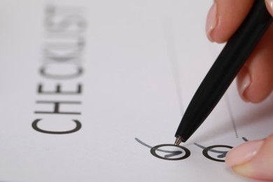 Photo of Woman filling Checklist with pen, closeup view