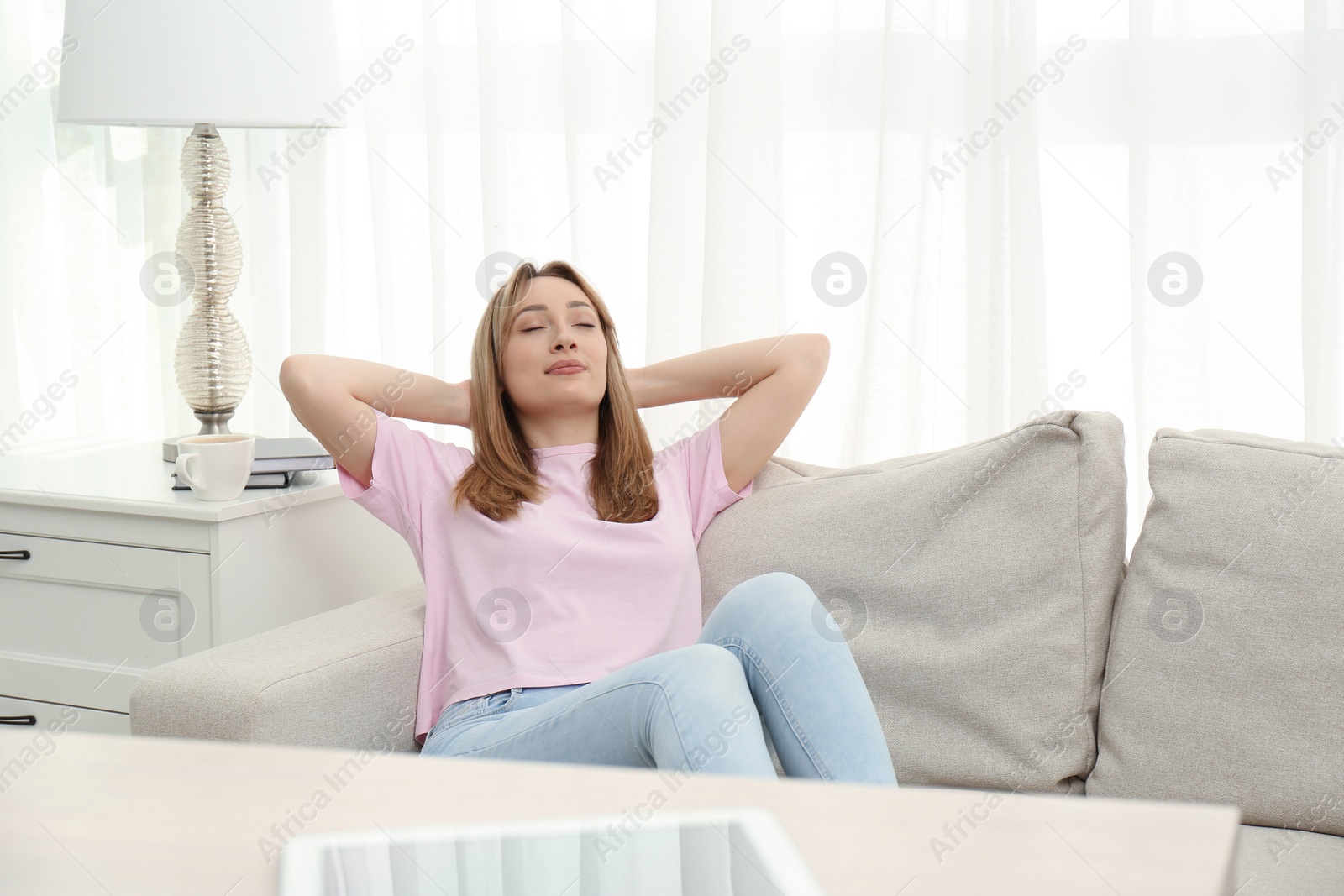 Photo of Beautiful young woman relaxing on sofa at home