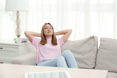 Beautiful young woman relaxing on sofa at home