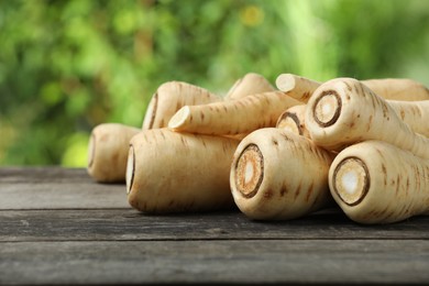 Delicious fresh ripe parsnips on wooden table outdoors, space for text