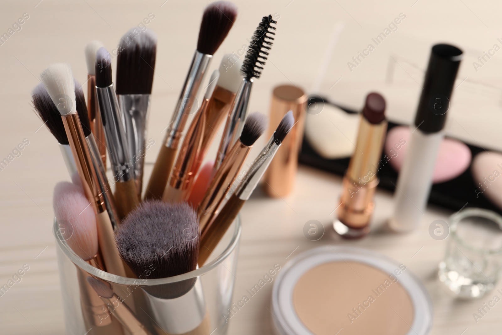Photo of Set of professional brushes and makeup products on table, closeup. Space for text