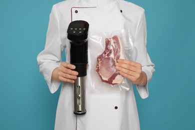 Chef holding sous vide cooker and meat in vacuum pack on light blue background, closeup