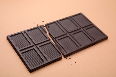 Photo of Broken tasty chocolate bar on brown background