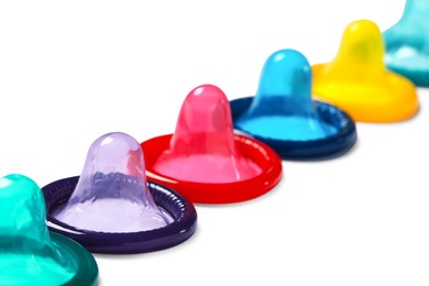 Colorful condoms isolated on white, closeup. Safe sex