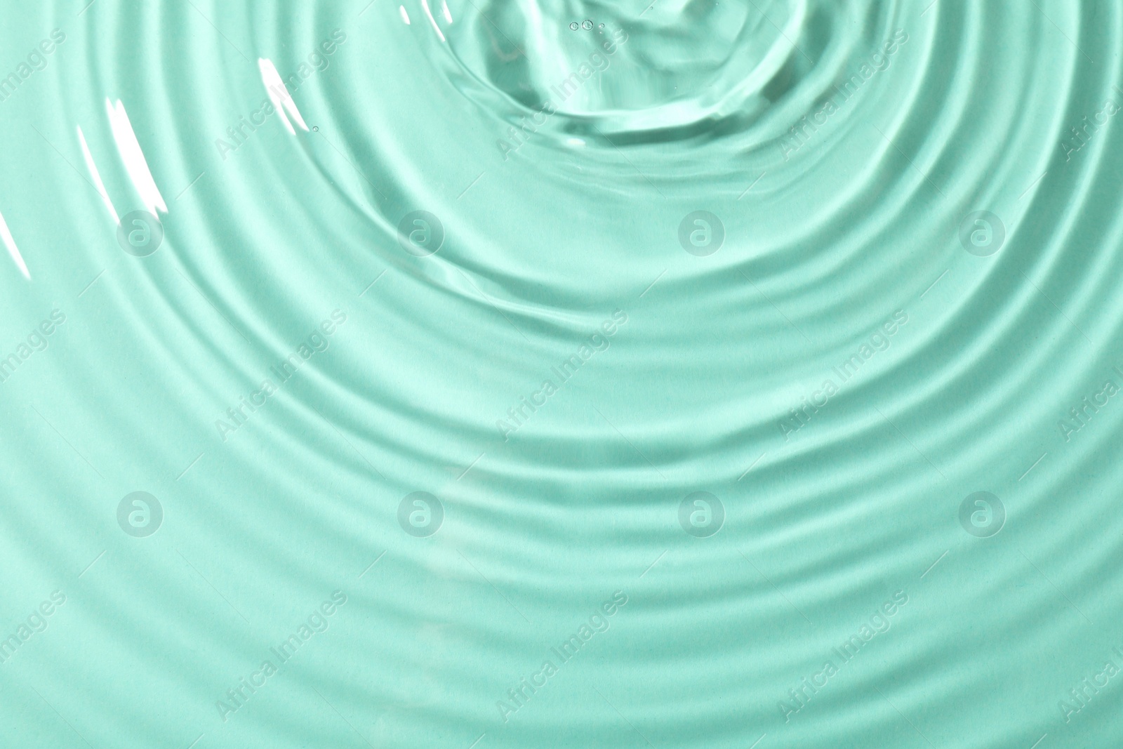 Photo of Closeup view of water with rippled surface on light blue background