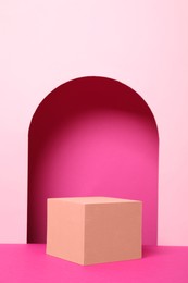 Photo of Orange geometric cube on pink background. Stylish presentation for product