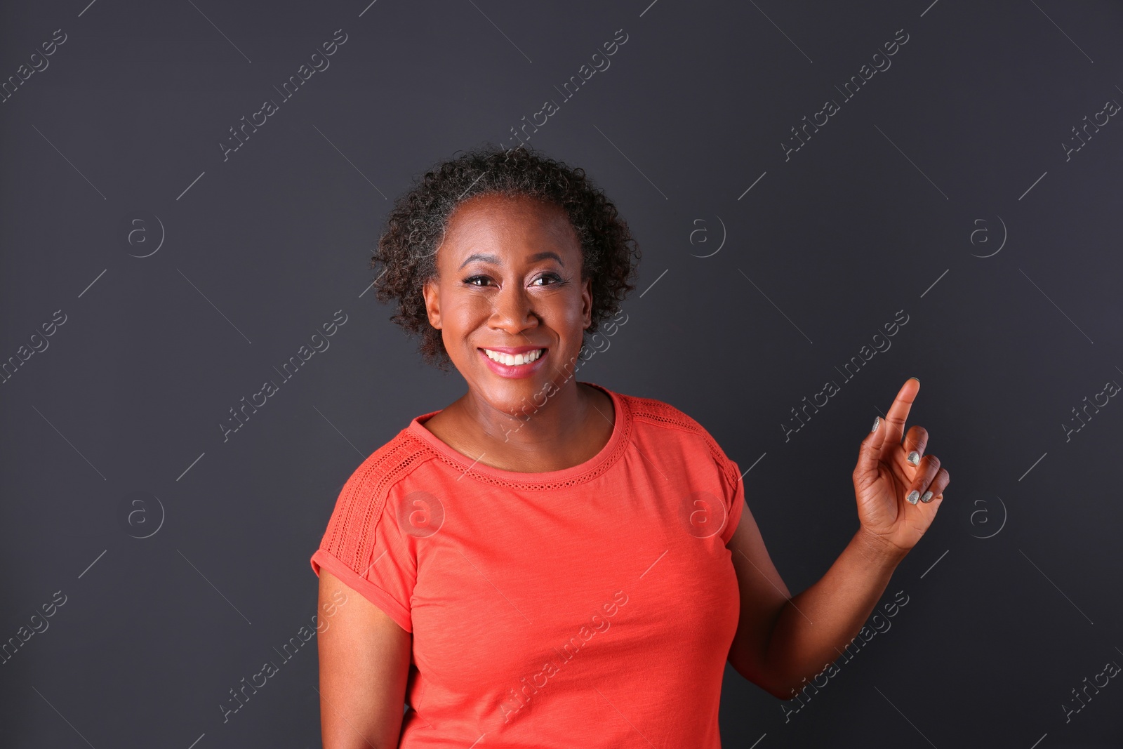 Photo of Portrait of happy African-American woman on black background